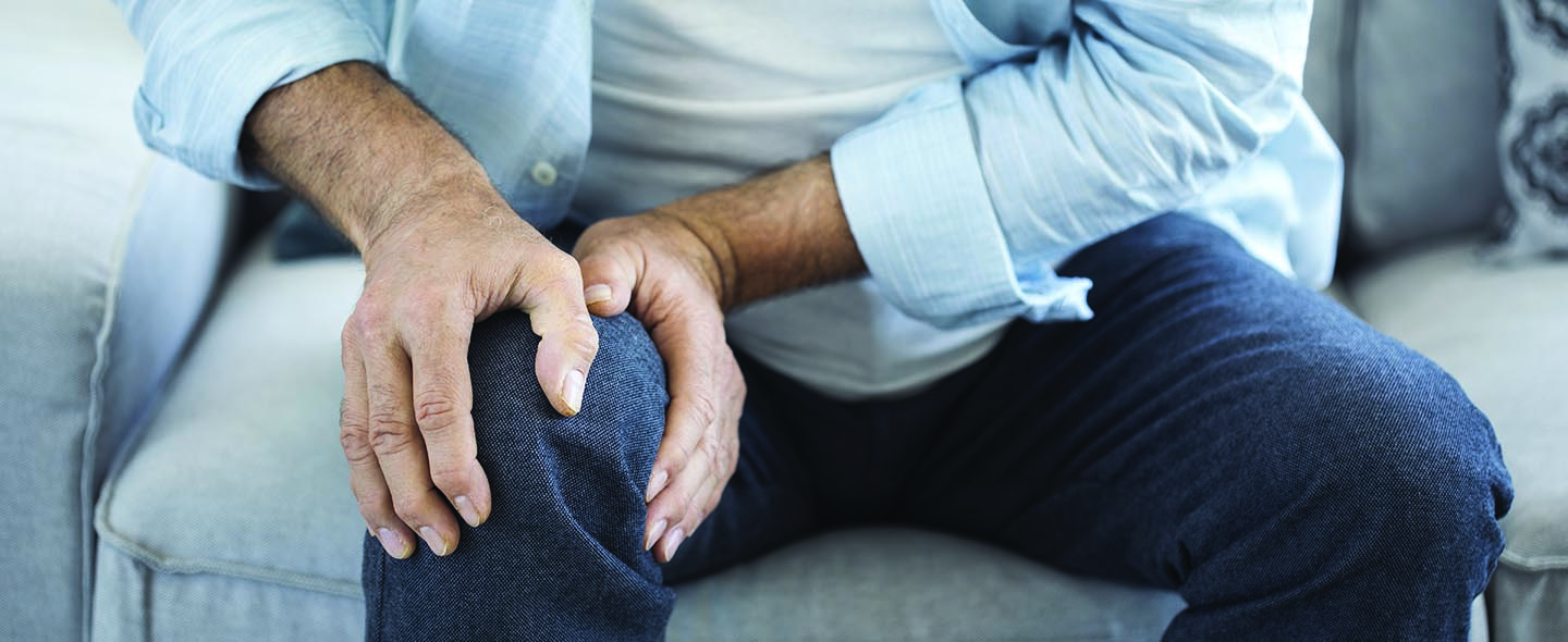 Man with pain holding knee